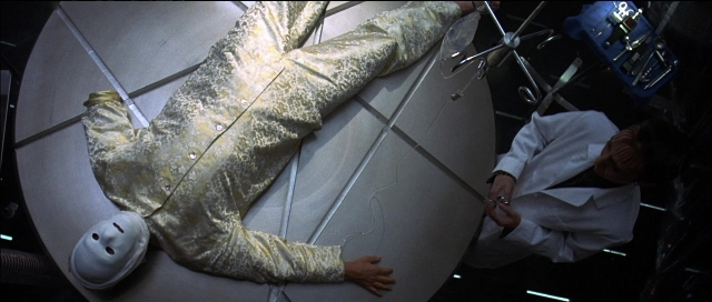 Wide shot frame from Tank Girl — coat, suit, face