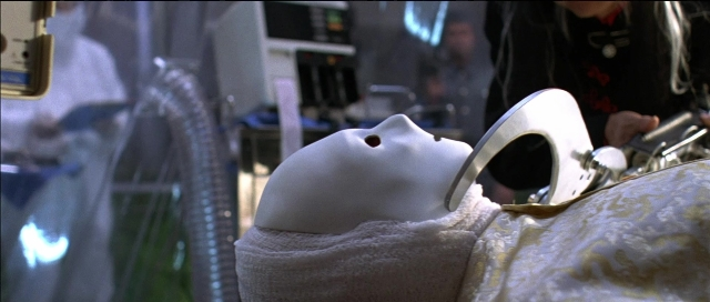 Wide shot frame from Tank Girl — bed, hand, person