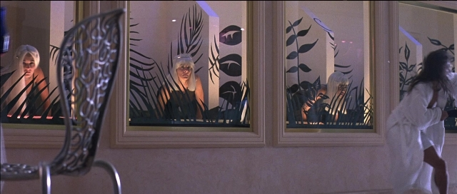 Wide shot frame from Tank Girl — standing, room, mirror