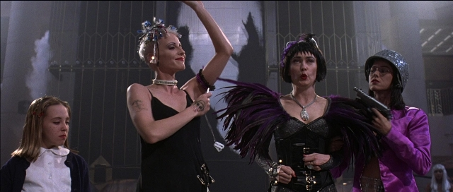 Wide shot frame from Tank Girl — dress, hair, smoke