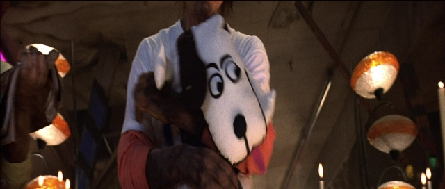 Wide shot frame from Tank Girl — standing, room, dog