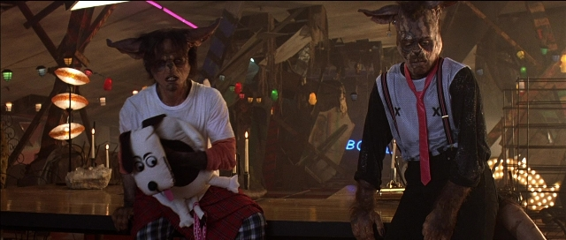 Wide shot frame from Tank Girl — standing, room, animal