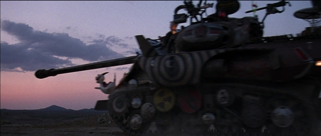 Wide shot frame from Tank Girl — car, gun, tank
