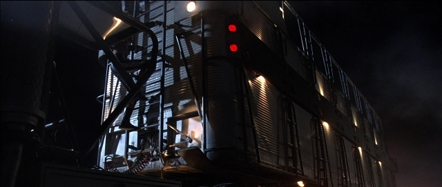 Wide shot frame from Tank Girl — running, building
