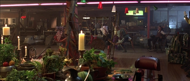Wide shot frame from Tank Girl — room, table, chair