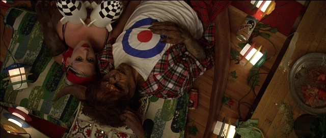 Wide shot frame from Tank Girl — plate, room, bed