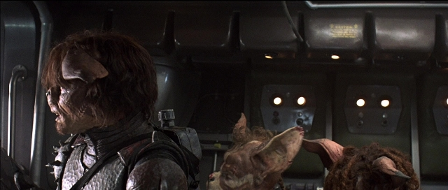 Medium shot frame from Tank Girl — standing, room, animal