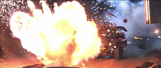 Wide shot frame from Tank Girl — car, gun, smoke
