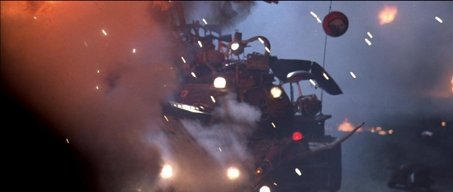 Frame from Tank Girl — fire, car, smoke
