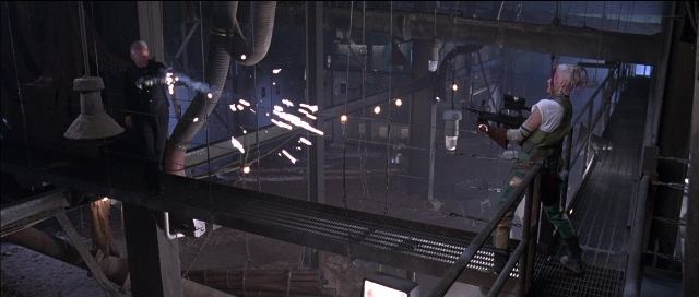 Wide shot frame from Tank Girl — standing, pipe, person