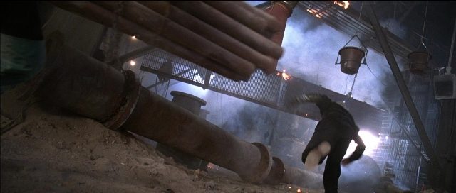 Wide shot frame from Tank Girl — hand, smoke, pipe
