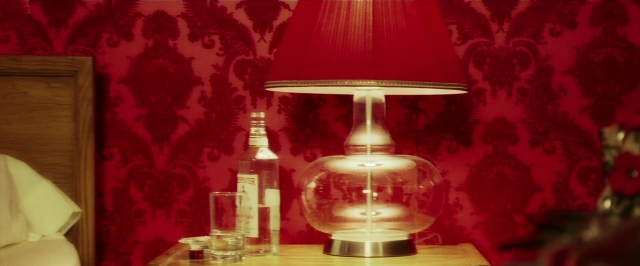 Wide shot frame from Lucky Number Slevin — table, bottle, lamp