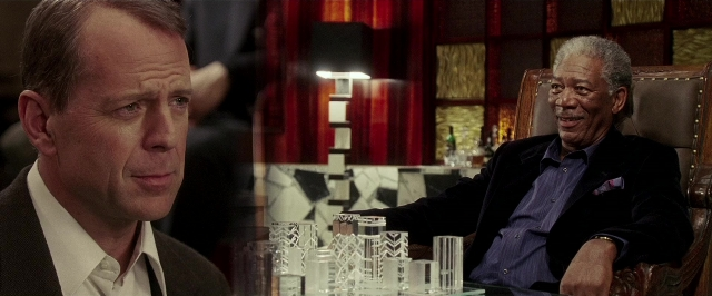 Medium shot frame from Lucky Number Slevin — sitting, table, suit