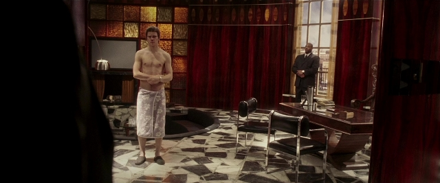 Wide shot frame from Lucky Number Slevin — standing, room, table