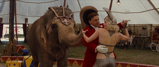 Wide shot frame from Water for Elephants — standing, hat, hand