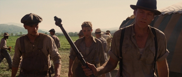 Medium shot frame from Water for Elephants — walking, hat, gun