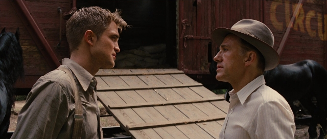 Wide shot frame from Water for Elephants — standing, dialogue, door
