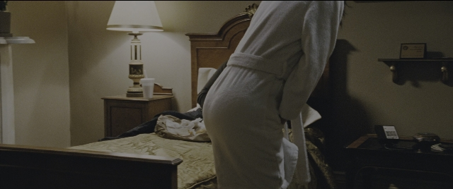 Wide shot frame from Jack Reacher: Never Go Back — standing, room, bed