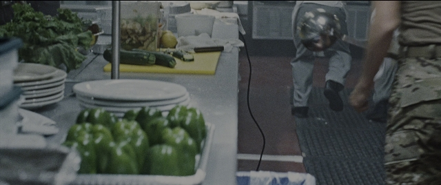 Wide shot frame from Jack Reacher: Never Go Back — hat, uniform, kitchen