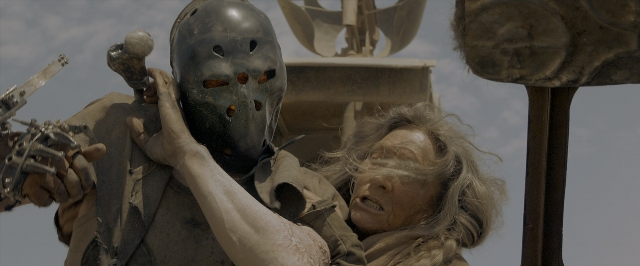 Wide shot frame from Mad Max: Fury Road — hand, face, hair