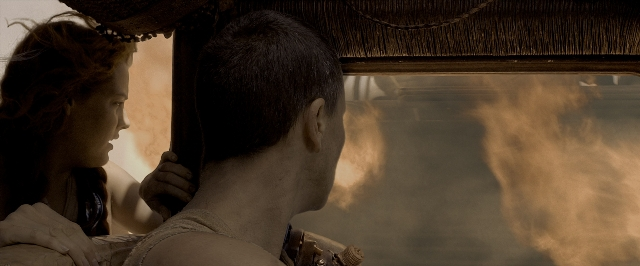 Wide shot frame from Mad Max: Fury Road — sitting, car, face