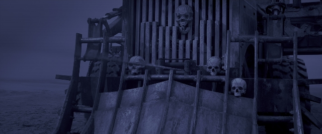 Medium shot frame from Mad Max: Fury Road — sitting, standing, skull