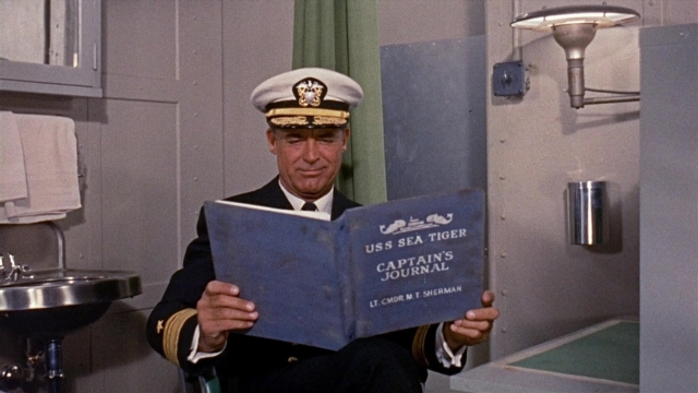 Wide shot frame from Operation Petticoat — sitting, book, hat