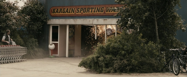 Wide shot frame from RocknRolla — bicycle, glass, person