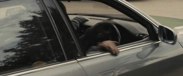 Wide shot frame from RocknRolla — street, mirror, car