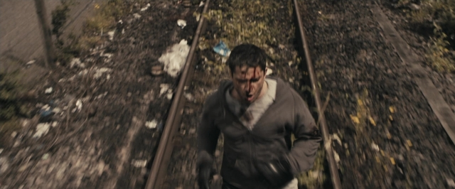 Wide shot frame from RocknRolla — walking, face, train