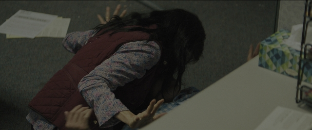 Wide shot frame from Everything Everywhere All at Once — sitting, shirt, office