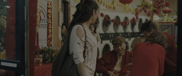 Wide shot frame from Everything Everywhere All at Once — sitting, standing, table