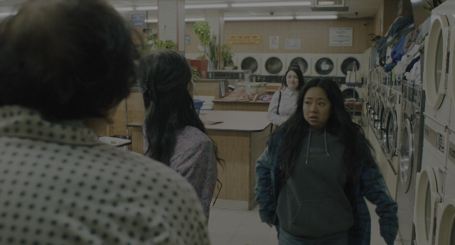 Wide shot frame from Everything Everywhere All at Once — standing, room, face
