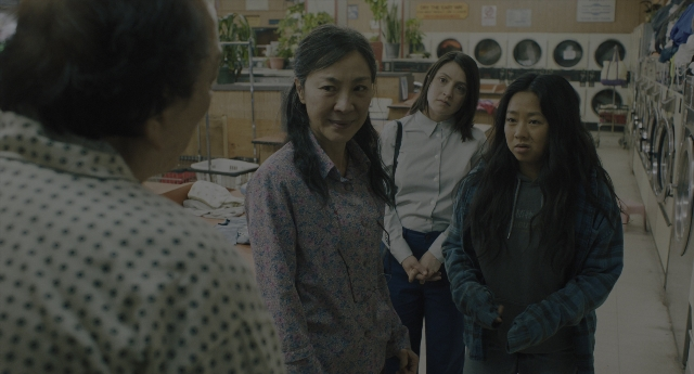 Wide shot frame from Everything Everywhere All at Once — standing, room, dialogue
