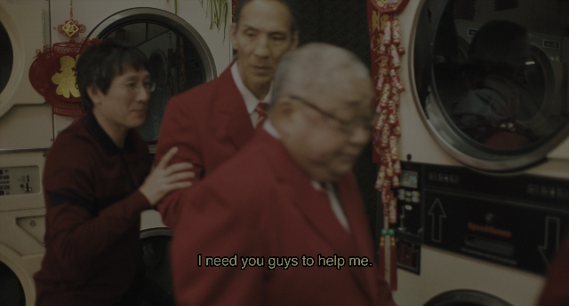 Wide shot frame from Everything Everywhere All at Once — standing, room, suit