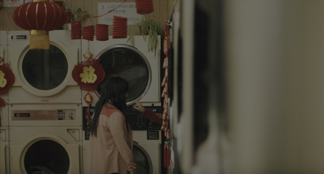 Wide shot frame from Everything Everywhere All at Once — standing, room, coat