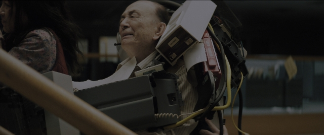 Wide shot frame from Everything Everywhere All at Once — standing, room, suit