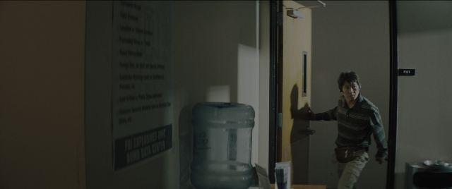 Wide shot frame from Everything Everywhere All at Once — standing, room, hand