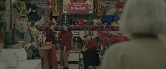Wide shot frame from Everything Everywhere All at Once — standing, beard, cup