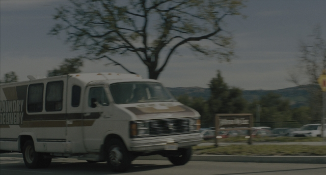 Wide shot frame from Everything Everywhere All at Once — street, car, van