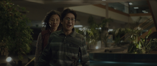 Wide shot frame from Everything Everywhere All at Once — standing, room, dialogue