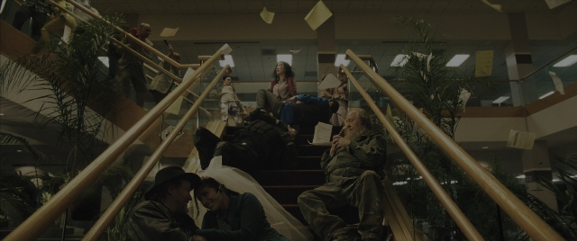 Wide shot frame from Everything Everywhere All at Once — sitting, book, standing