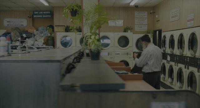 Wide shot frame from Everything Everywhere All at Once — standing, room, bottle