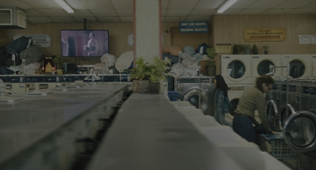 Wide shot frame from Everything Everywhere All at Once — standing, room, shirt