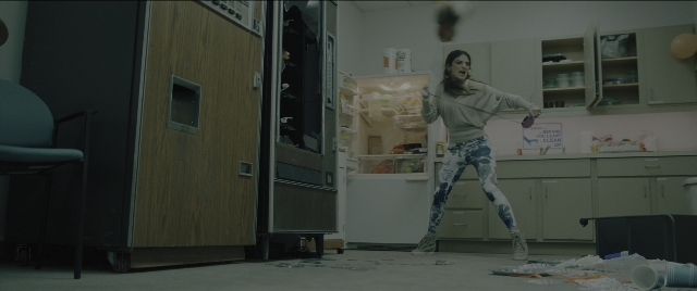 Wide shot frame from Everything Everywhere All at Once — standing, room, chair