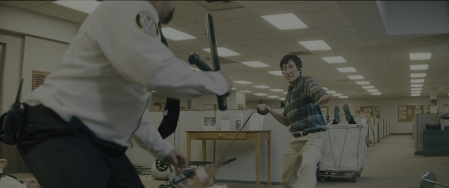 Wide shot frame from Everything Everywhere All at Once — standing, room, table