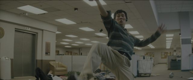 Wide shot frame from Everything Everywhere All at Once — standing, shirt, office