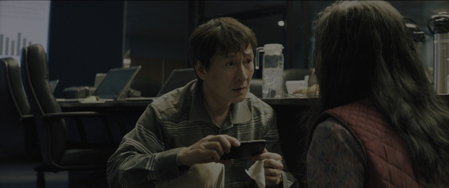 Wide shot frame from Everything Everywhere All at Once — sitting, table, phone