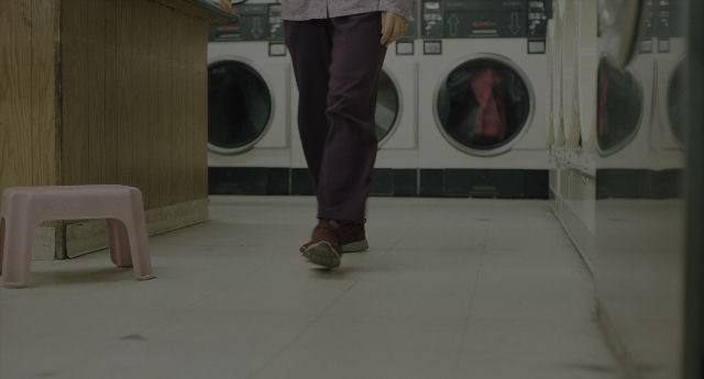 Wide shot frame from Everything Everywhere All at Once — walking, room, shirt