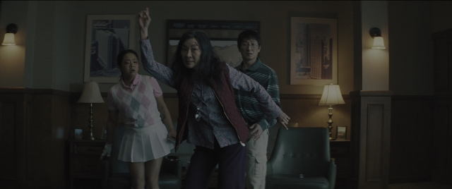 Wide shot frame from Everything Everywhere All at Once — standing, room, shirt
